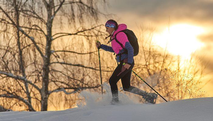 a young sporty girl runs with snowshoes